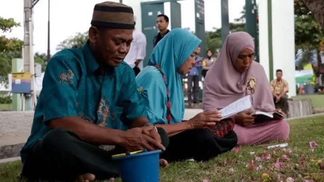 Keluarga korban tengah berdoa pada peringatan 13 tahun bencana tsunami di Banda Aceh, 26 Desember 2017.