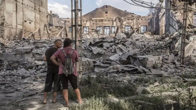 Locals look at destroyed buildings in Lysychansk after heavy fighting in the Luhansk area, Ukraine,