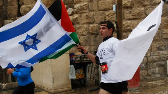 ఇజ్రాయెల్, పాలస్తీనా జెండాలతో మారథాన్‌లో పాల్గొన్న వ్యక్తి