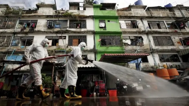 เจ้าหน้าที่ดับเพลงช่วยกันฉีดยาฆ่าเชื้อในพื้นที่ตลาดค้าส่งกุ้งแห่งหนึ่งในจังหวัดสมุทรสาคร หลังพบแม่ค้าติดเชื้อในประเทศ