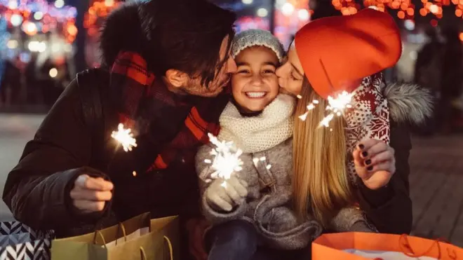 Padres besando a su hija en Navidad.