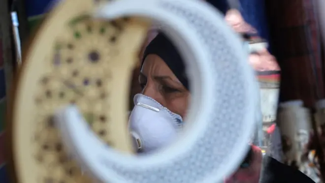 Haweeney Ciraaq ku nool oo xiran maaskiga wejiga oo u adeegsaneysa bisha ramdan