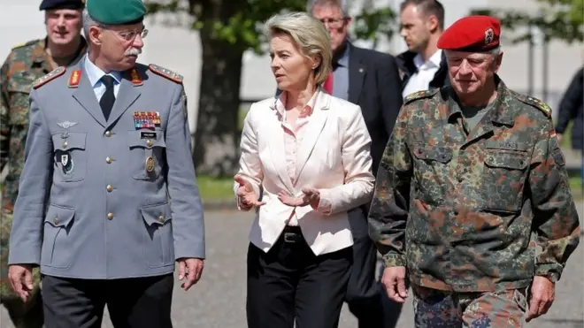 Mentri pertahanan Jerman (tengah) mengatakan penghormatan terhadap angkatan bersenjata Hitler sudah tidak relevan bagi pasukan Jerman di jaman modern ini.