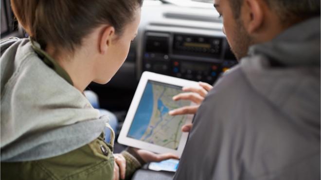 Homem e mulher olham um mapa na tela de um tablet