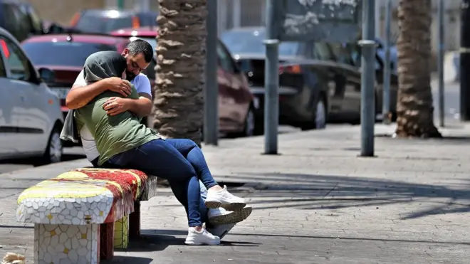 A Lebanese couple without face masks hug on a bench on the Corniche in Beirut, Lebanon, 30 July 2020