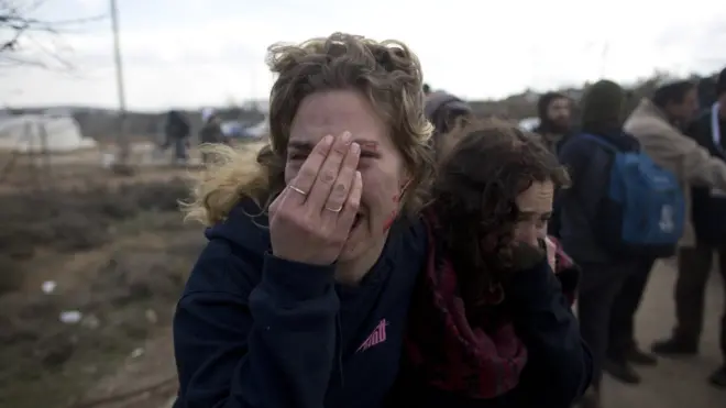 Israeli settlers cover their face as security forces arrive to the illegal Jewish settlement in Amona, West Bank, on February 1, 2017