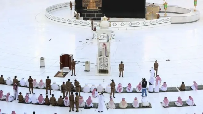 Suasana di dekat Kabah, Masjidil Haram, Mekkah, Arab Saudi, Minggu (24/05), saat sebagian karyawan dan pekerja masjid melakukan salat dengan dikawal aparat keamanan, di tengah pandemi virus corona.