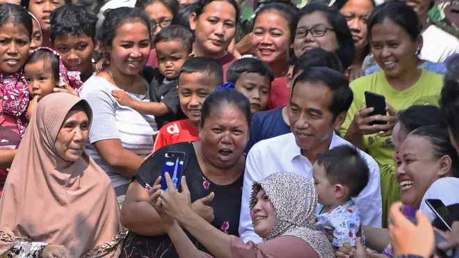 Capres petahana Joko Widodo menyapa warga sebelum menyampaikan pidato kemenangannya sebagai Presiden Republik Indonesia periode 2019-2024 di Kampung Deret, Tanah Tinggi, Johar Baru, Jakarta Pusat, Selasa (21/5/2019).