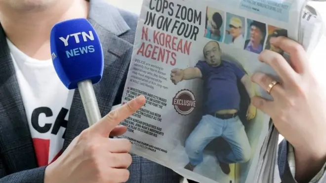 Seorang wartawan menunjukkan koran Malaysia dengan berita utama kasus Kim Jong-nam saat menyampaikan laporannya.