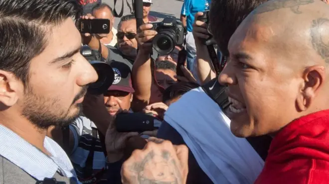 Dos hombre en actitud de fuerte discusión; al fondo, cámaras de televisión