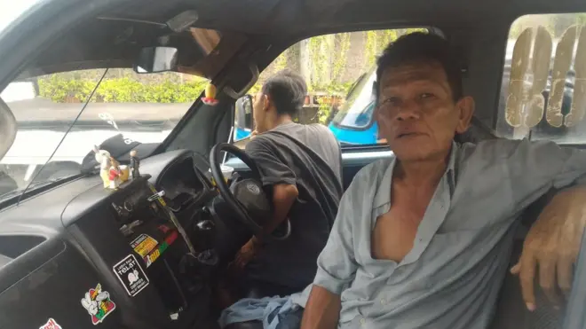 Manalu dan putranya saat sedang menunggu giliran mengangkut penumpang di samping Stasiun Tanah Abang, Jakarta Pusat.