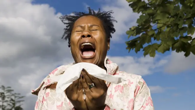 Une femme qui éternue en plein air