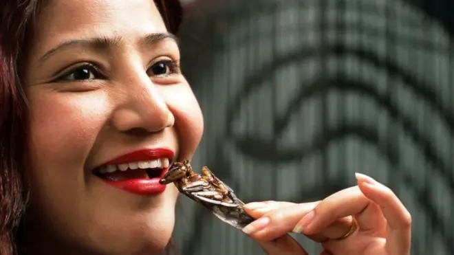 మిడతలను తింటున్న మహిళ