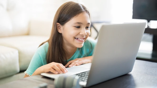 Niña mirando computadora.
