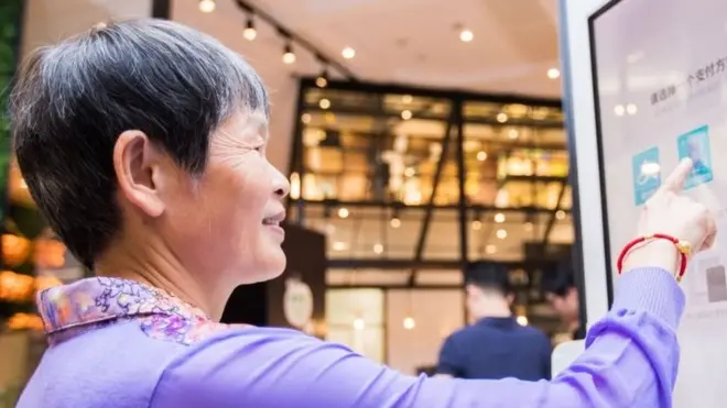 امرأة صينية تستخدم نظام "اببسم وادفع" في مطعم كنتكي