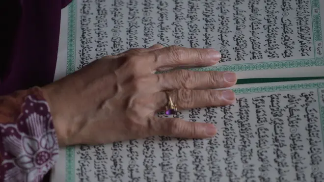 يد امرأة من أندونيسيا تقرأ القرآن
