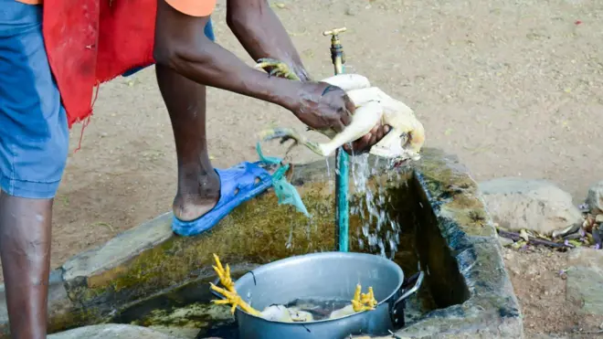 Un homme qui lave un poulet