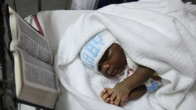 Mtoto akiwa amelala pembeni ya biblia katika hospitali moja huko Lagos