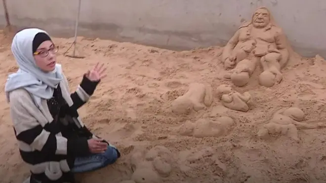 فلسطينية تنحت على الرمال هموم شعبها