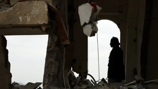 يمني يجلس وسط أنقاض منزل