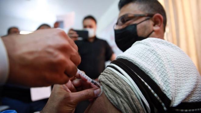 عاملون صحيون يتلقون لقاح فيروس كورونا خلال حملة تطعيم في بغداد