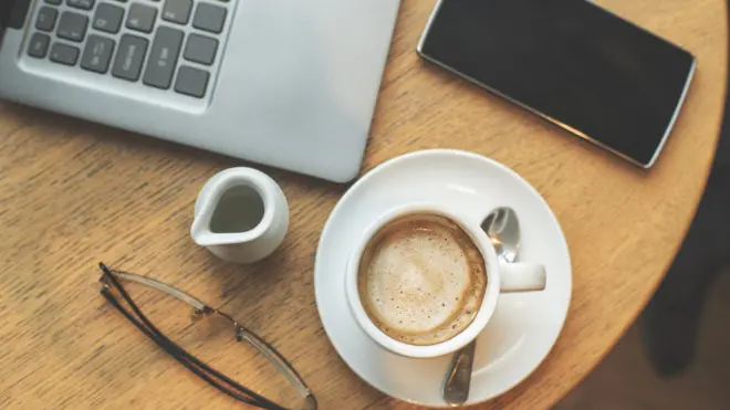 Working table with coffee, cell phone and computer