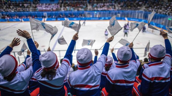 Fans waving the flag of a unified Korea support their hockey players against Japan.
