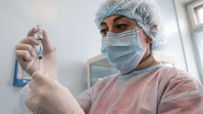 A nurse fills her syringe with component 1 of the Sputnik V vaccine