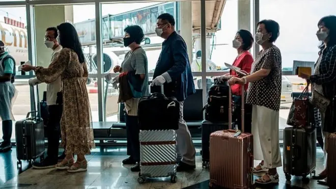 Baadhi ya raia wa kigeni waliowasili katika uwanja wa Entebbe nchini Uganda wakipiga foleni ya kukaguliwa