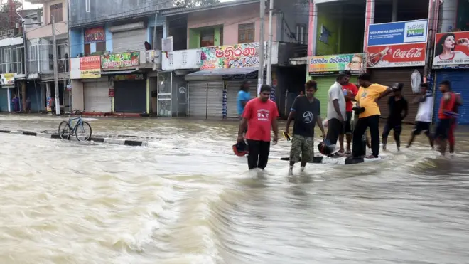 Sri Lankan residents make their way through floodwaters in Kaduwela on May 27, 2017. Rainfall on May 26 triggered the worst flooding and landslides in 14 years in the southern and western parts of Sri Lanka, authorities said. The Disaster Management Centre (DMC) said 103 people were confirmed killed while another 113 were missing. / AFP PHOTO / ISHARA S. KODIKARA (Photo credit should read ISHARA S. KODIKARA/AFP/Getty Images)