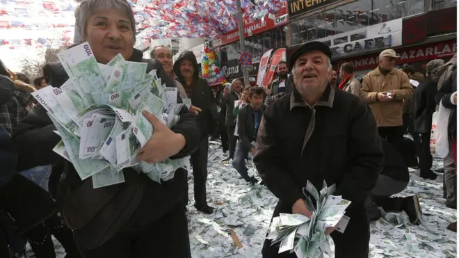 Türkiye'deki bir gösteride ellerinde euro tutanlar.