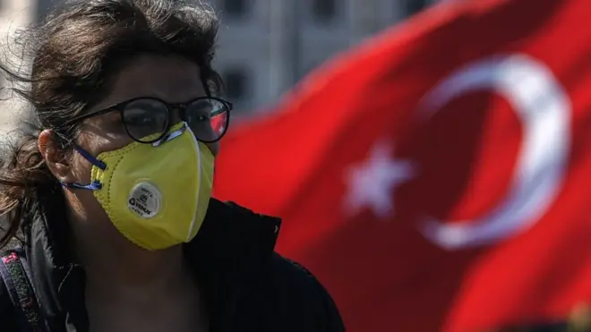 türk bayrağı ve maske takan bir kadın