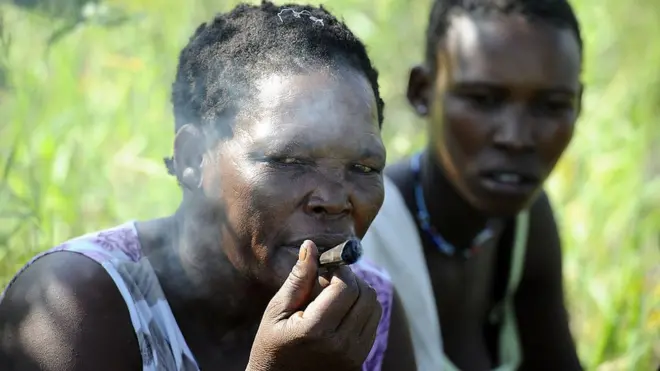 Une femme bushman fumant une cigarette.