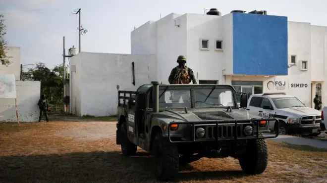 Troops stand guard at the morgue where the Americans' bodies were taken
