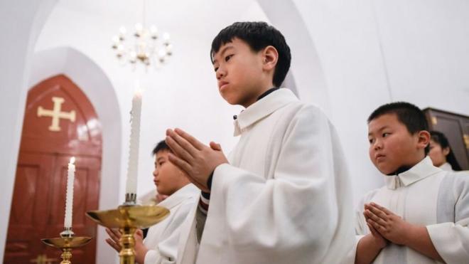 2018年12月24日，年輕的基督教徒在北京一所教堂參加彌撒。