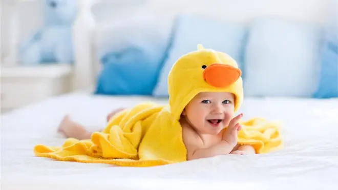 Banyo havlusuna sarılı gülümseyen bebek