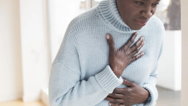 A woman holding on to her chest in pain