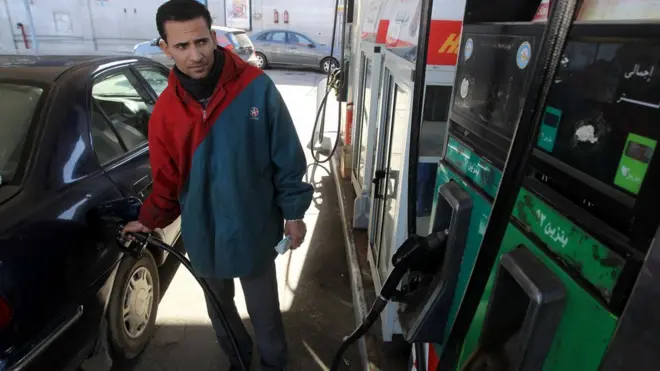 عامل يملأ سيارة بالبنزين