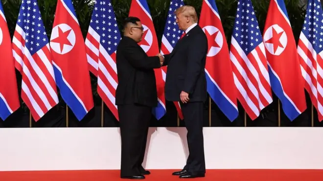 Kim Jong-un and Donald Trump shake hands during their unprecedented meeting