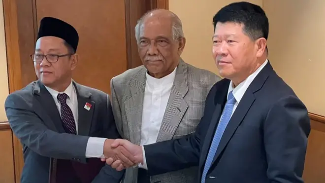 อุซตาสอานัส อับดุลเราะห์มาน หัวหน้าคณะบีอาร์เอ็น (ซ้าย) จับมือกับ พล.อ.วัลลภ รักเสนาะ หัวหน้าคณะพูดคุยสันติสุขฯ (ขวา) โดยมีตันซรี อับดุล ราฮิม บิน โมฮัมหมัด นอร์ ผู้อำนวยความสะดวกจากมาเลเซีย อยู่ตรงกลาง