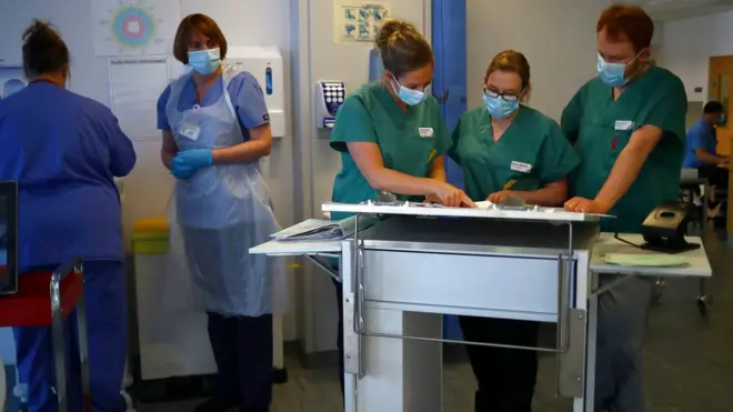 Medical staff consult a chart in hospital