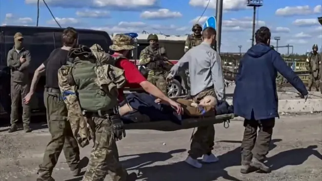 Otro combatiente herido es trasladado en una camilla.