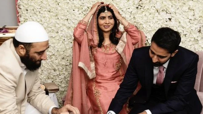 Malala ajuste son voile pendant qu'Asser Malik signe le certificat de mariage.