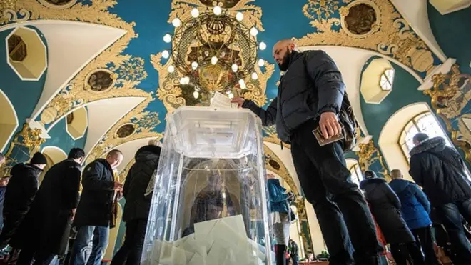 Люди голосують на виборчій дільниці у залі Казанського вокзалу, Москва.