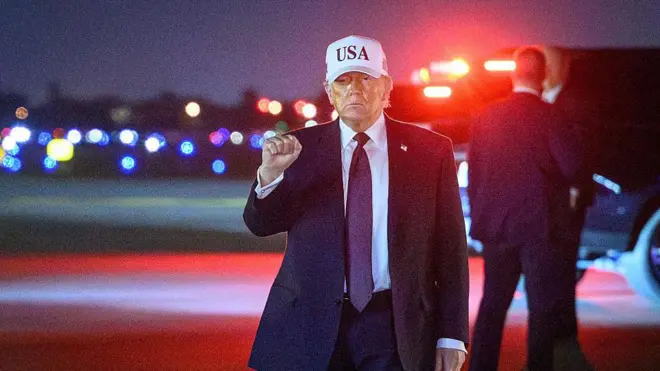 دونالد ترامپ با کلاه سفید، مشتش را بالا برده است