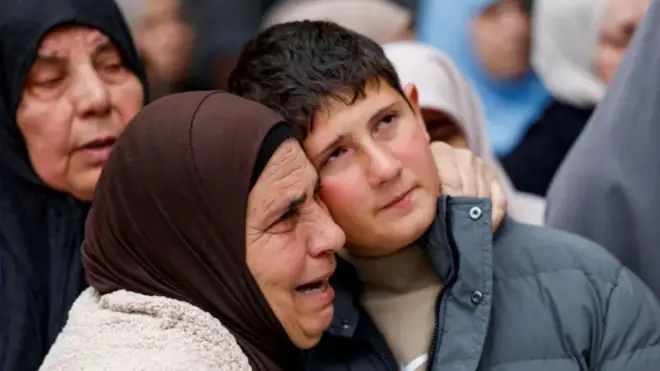 Khaled Bani Odeh es abrazado por una mujer durante el funeral de sus padres y sus dos hermanos en Tammun, Cisjordania ocupada (15 de marzo 2026)