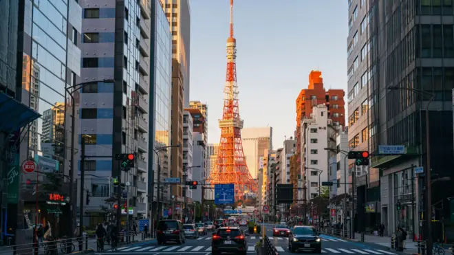 Tokyo Kulesi günbatımında işlek bir caddenin sonunda görünüyor. 