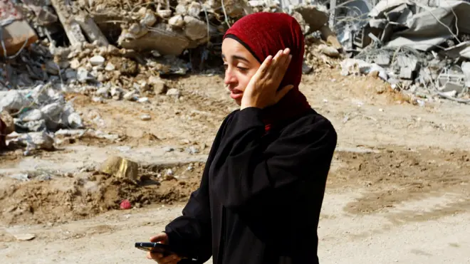 ग़ज़ा पट्टी से भागती हुई एक फ़लस्तीनी महिला