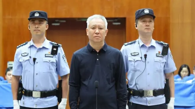 許家印（中）在法警押送下，於中國廣東深圳市中級法院出庭（深圳中級法院圖片20/8/2026）