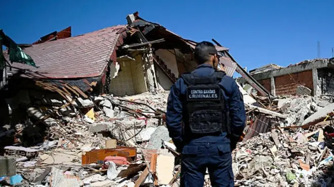 Policía frente a una casa derruida en El Junquito.